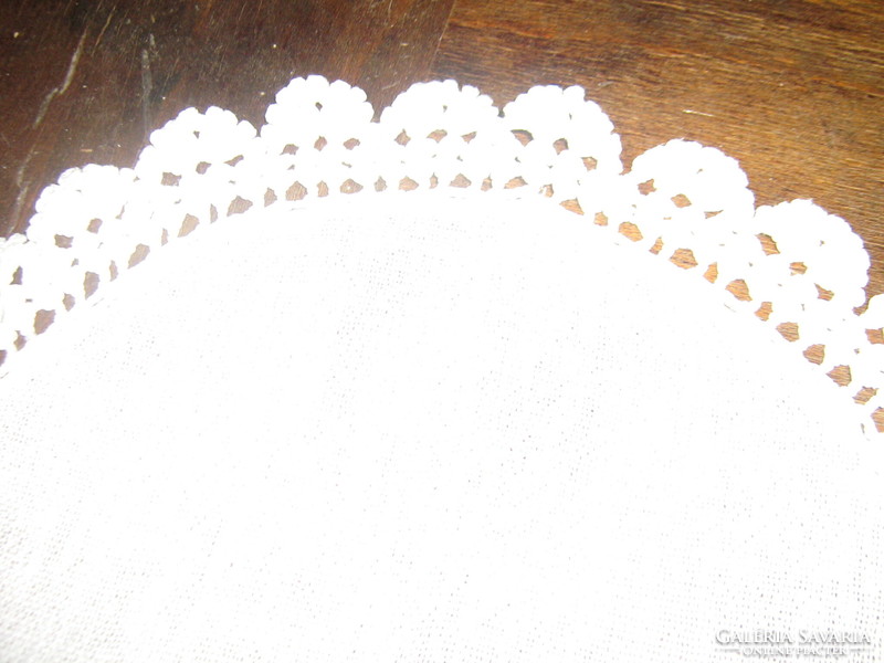 A beautiful hand-crocheted snow-white table centerpiece with a lace edge
