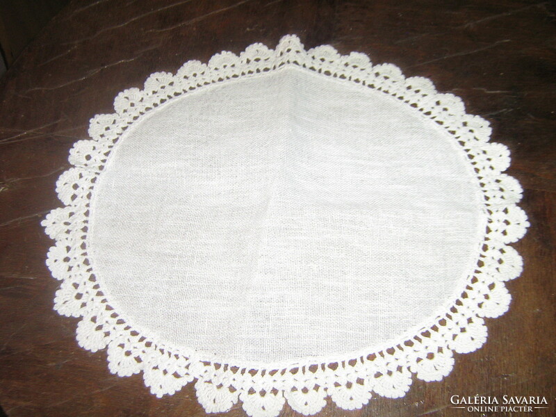 A beautiful hand-crocheted snow-white table centerpiece with a lace edge