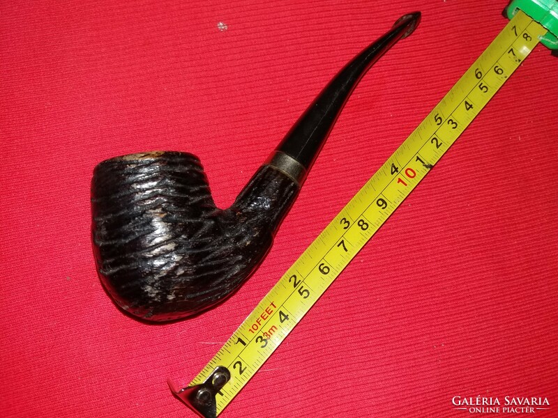 An old wooden pipe with a curved stem and a ribbed head, beautifully carved according to the pictures 3.