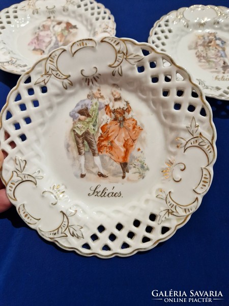 Áttört szélű porcelán dísz tányérok jelenetes képpel.