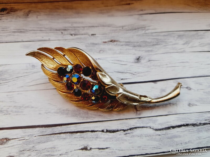 Golden brooch with rhinestones, in the shape of a leaf