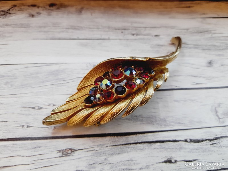 Golden brooch with rhinestones, in the shape of a leaf