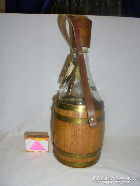 Stari vinjak - retro glass bottle - in a copper barrel with a wooden cap