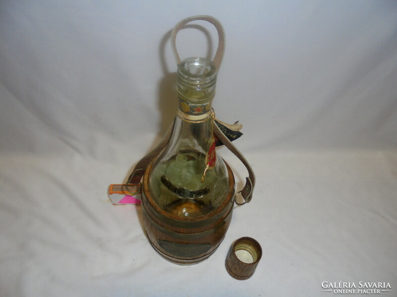 Stari vinjak - retro glass bottle - in a copper barrel with a wooden cap