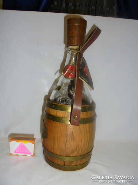 Stari vinjak - retro glass bottle - in a copper barrel with a wooden cap