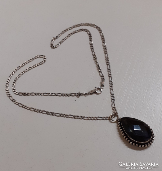 In good condition, a necklace with a carved pattern marked on it with a marked silver pattern with a silver set stone pendant