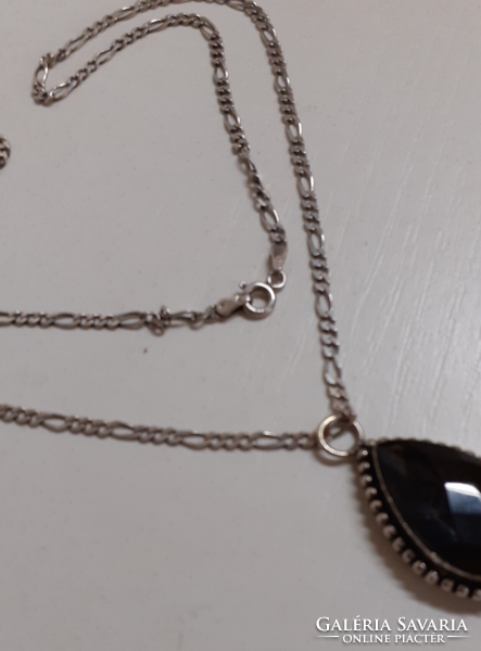 In good condition, a necklace with a carved pattern marked on it with a marked silver pattern with a silver set stone pendant