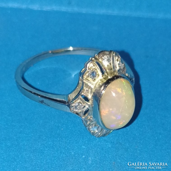 Gold ring with opal stones, sparkling with brilliants in the circle