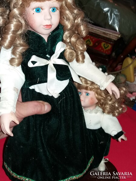 Antique beautiful porcelain doll brother and sister the sister and the little sister on a wooden surface the bigger one is 45 cm the smaller one is 23 cm