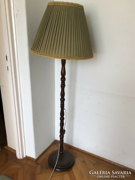 Wooden floor lamp with an olive green lampshade and gold border