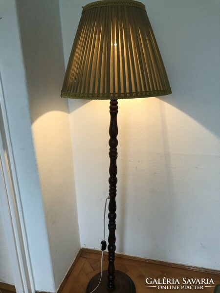 Wooden floor lamp with an olive green lampshade and gold border