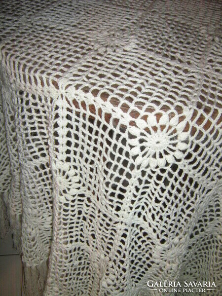 A beautiful white hand-crocheted fringe tablecloth