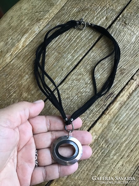 Silver pendant with silver fittings on a leather necklace