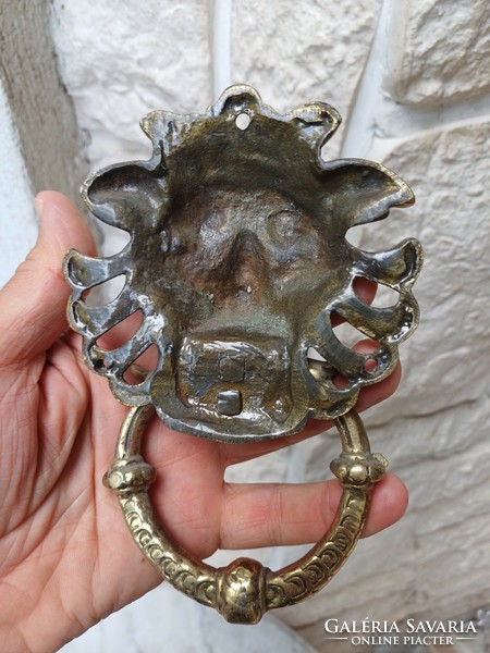 A knocker with a lion's head made of copper. Also a video!