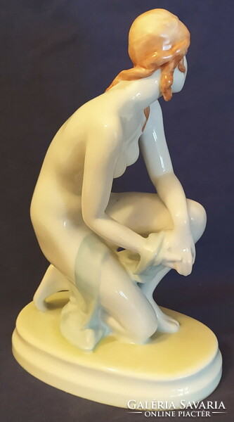 Statue of a female nude kneeling on an antique Zolnay pedestal