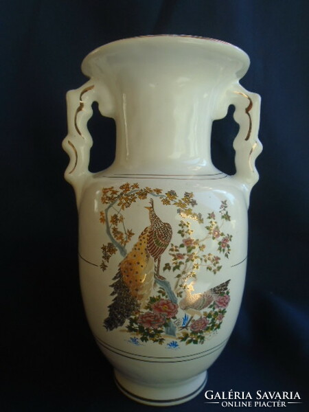 The empire-style vase decorated with peacock birds is contoured in real gold