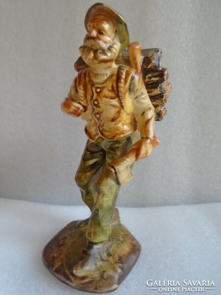 A small curio of a man carrying firewood with an ax in his hand, showcase condition, brilliant color scheme