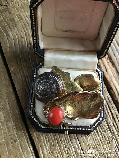 Old gold-plated silver brooch decorated with silver shells and precious coral stones.
