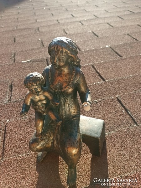 The small plastic statue of Rose Pató _ mother with child _ is damaged