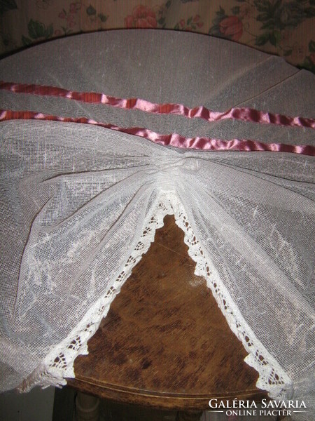 Beautiful vintage crocheted rococo style curtain decorated with dark pink ribbon with lace edge