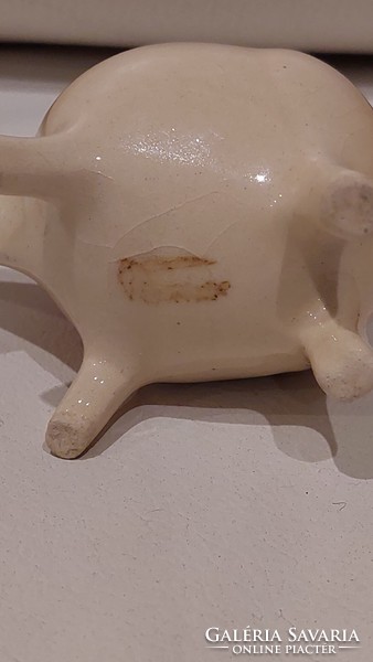 Marked figure holding a pin in the shape of a pig