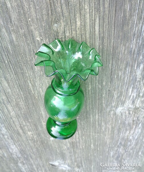 Old green broken glass vase with ruffled edges