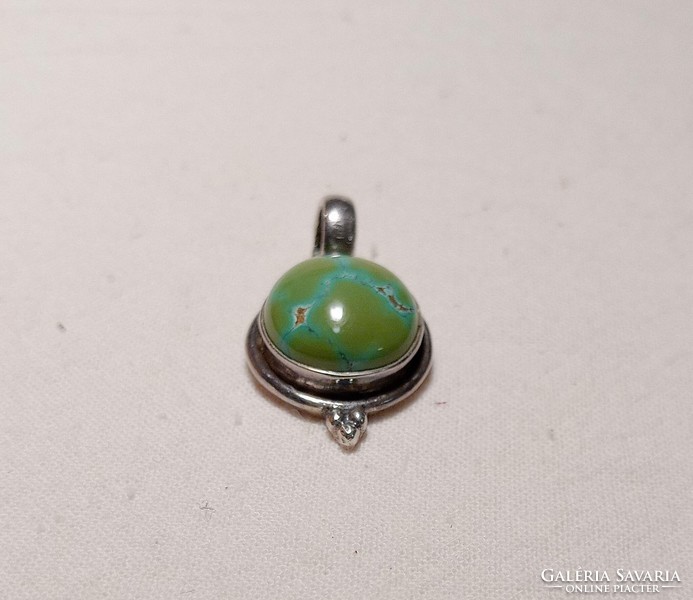 Old silver pendant with a large greenish turquoise