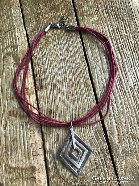 Silver pendant with silver fittings on a cord necklace