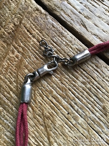 Silver pendant with silver fittings on a cord necklace