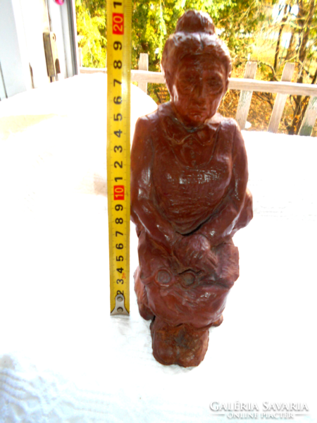 Statue of an old woman with a book and glasses in her lap