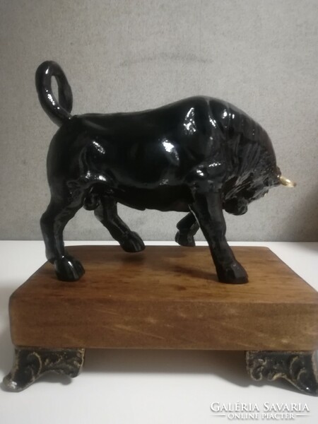 Enraged cast iron bull with black and gold horns.