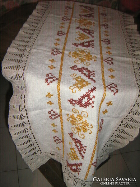 A beautiful folk traditional cross-stitch hand-embroidered tablecloth with a lace edge