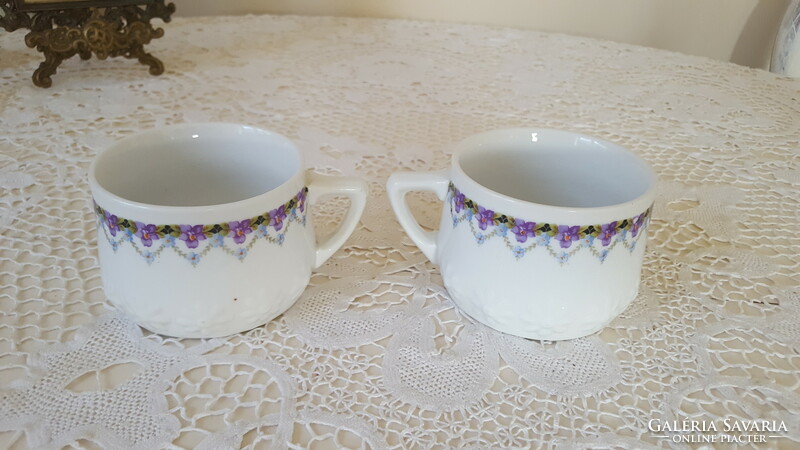 2 porcelain mugs with an embossed flower pattern and garland.