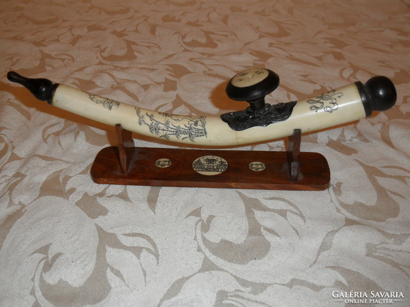 Far Eastern hand-painted, bone opium pipe on a wooden stand