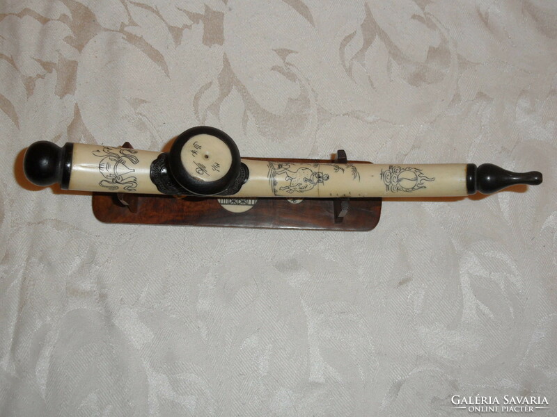 Far Eastern hand-painted, bone opium pipe on a wooden stand