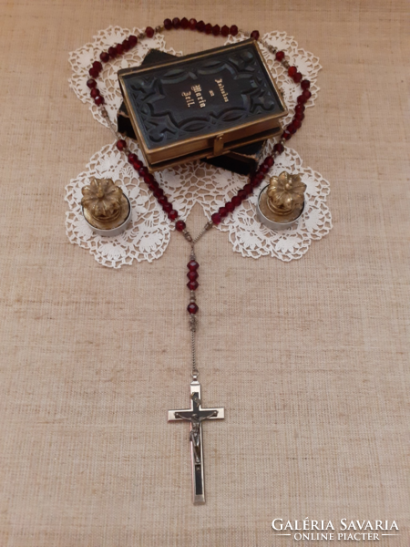 Old nun's heirloom prayer book with buckle, rosary on a lace tablecloth with a gift candle