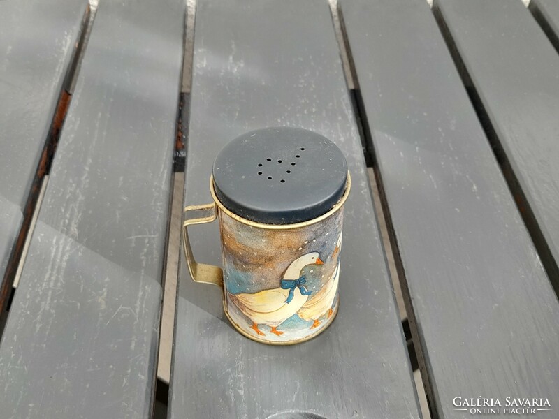 A tiny metal jar, perhaps a children's kitchen accessory