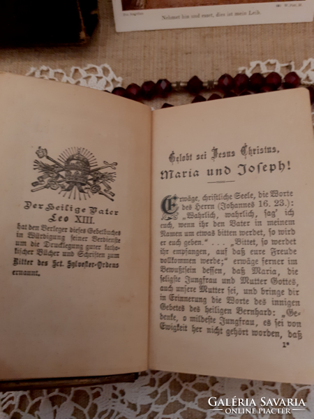 Old nun's heirloom prayer book with buckle, rosary on a lace tablecloth with a gift candle