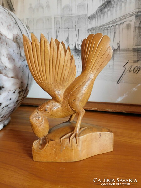 Carved wooden bird preying on fish