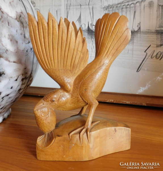 Carved wooden bird preying on fish