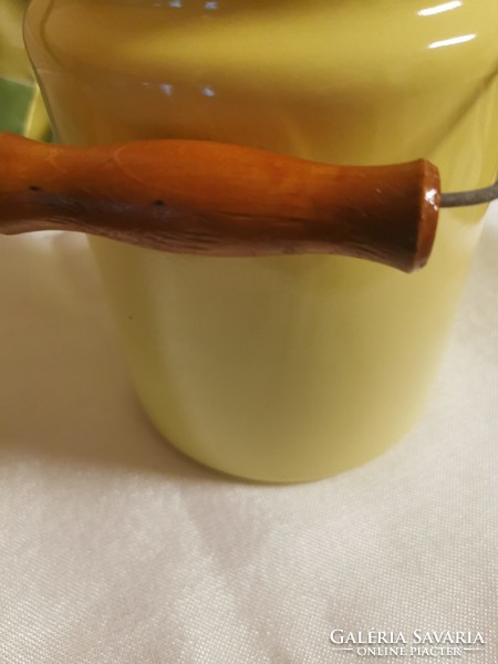Old 3 l yellow enameled milk jug with wooden handle.