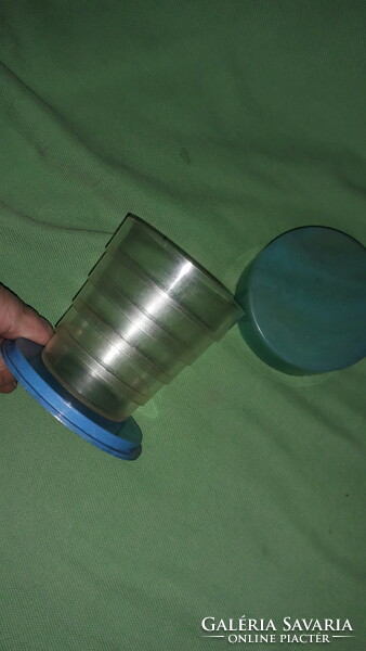 The kindergarten bag is old and the telescopic plastic cup 2 is an essential accessory for school trips.