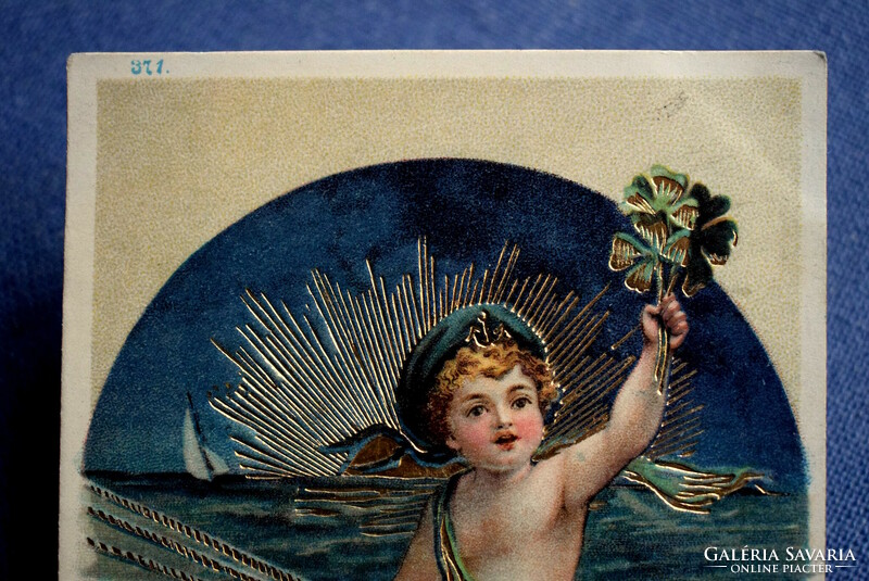 New Year greeting card pressed with antique gold - little sailor on a ship, 4-leaf clover, golden sunset
