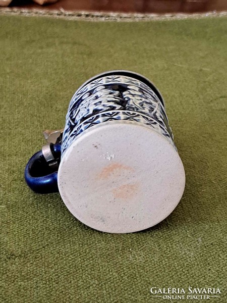 Mini blue patterned ceramic beer mug with opening cap on the top, the marking on the bottom is blurred