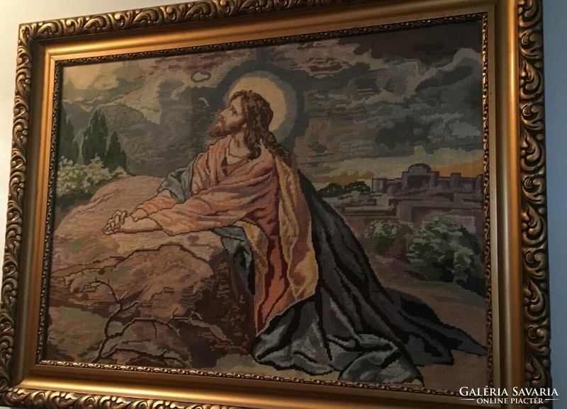 A large, religious-themed picture, made with Gobelin technique, in a gilded frame.