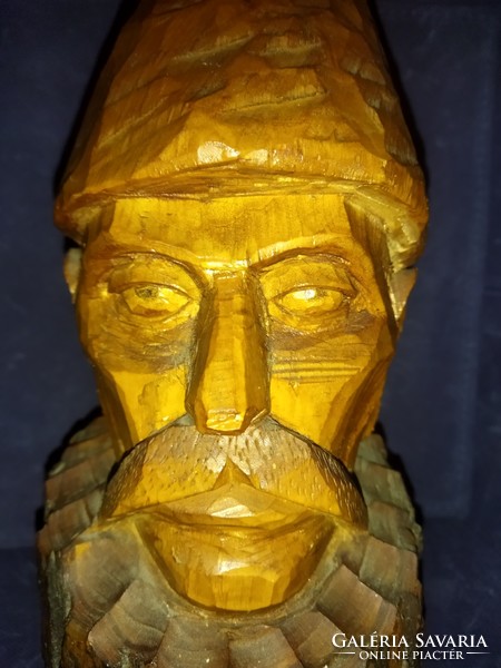 A peasant man, carved from wood, wearing a large folk hat. Wooden sculpture!