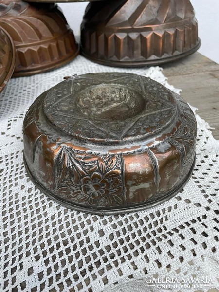 A very old copper baking dish resembling a floral Star of David