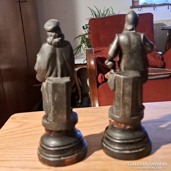 A pair of antique statues, cast iron on a wooden plinth