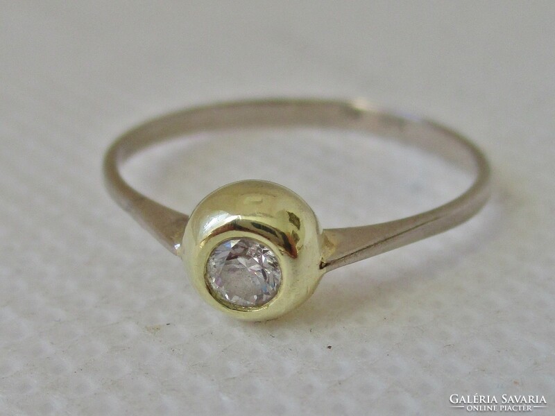 Elegant 18kt gold ring with a white stone in a button setting