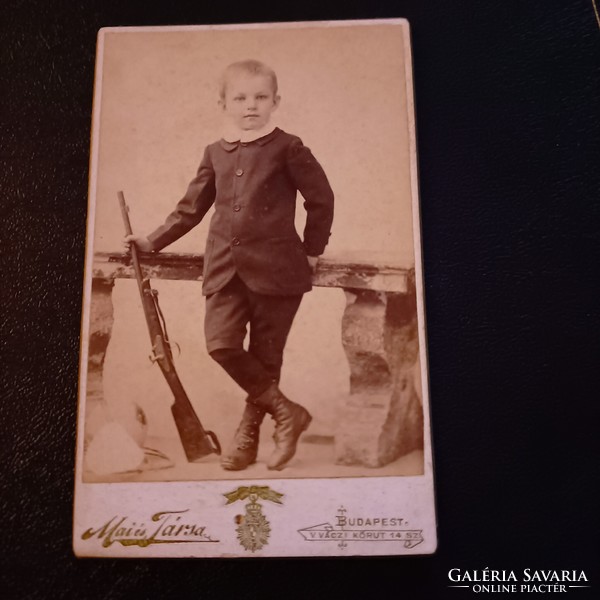 Photo of a small child with a rifle in his hand